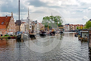 The Galgewater canal in Leiden, Netherlands, with old ships and houseboats.