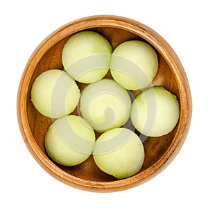 Galia melon balls, also known as sarda melon, in a wooden bowl photo