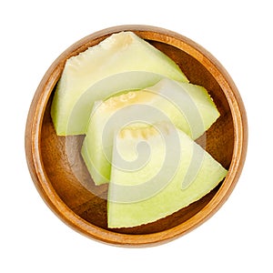 Galia melon slices, also known as sarda melon, in a wooden bowl