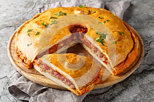 Galician Pie or Empanada Gallega stuffed with tuna or meat and vegetables closeup on the board. Horizontal