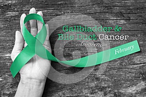 Gallbladder or Bile Duct Cancer Awareness ribbon kelly green on helping hand