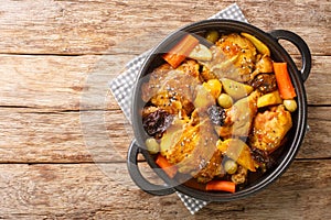 Gallo en chicha is a rooster cooked in a fermented corn drink with vegetable and spices closeup on the pan. Horizontal top view