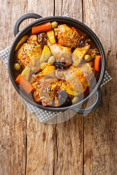 Gallo en chicha Salvadoran chicken braised in fizzy and tangy pineapple chicha with vegetables closeup on the pan on the wooden