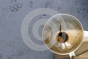 Gallon of engine oil with a oil filling funnel on the ground after filled in a car repair shop