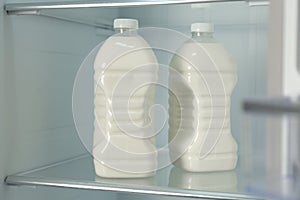 Gallons of fresh milk in refrigerator, closeup