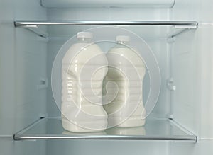 Gallons of fresh milk in refrigerator, closeup