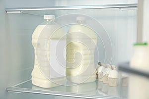 Gallons of milk near eggs in refrigerator, closeup