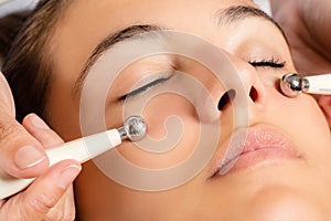 Galvanic facial treatment with low level current electrodes. photo