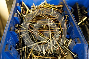 Galvanized deck screws in bucket in a factory workshop