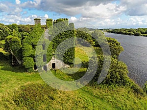 08/18/2019 Galway city, Ireland. Old overgrown buildings of Menlo Castle on River Corrib, Cloudy sky