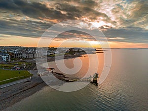 Galway, Ireland - 04.30.2021: Sun rise over Galway city, People swimming in the ocean by Blackrock public diving board. Calm