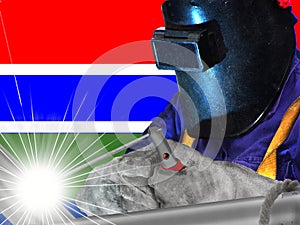 GAMBIA WELDER WITH BACKGROUND OF HIS