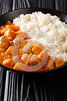 Gambian Domoda meat in peanut sauce served with rice in a dish. vertical