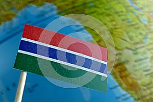Gambian flag with a globe map as a background