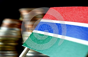 Gambian flag waving with stack of money coins