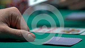 Gambler checking cards, losing combination, bad luck poker hands, bankrupt