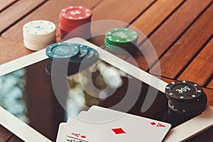 Side view of a green poker table with some poker cards on a keyboard. Betting on-line concept