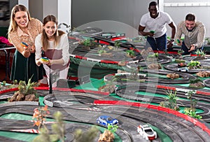 Gambling friends play in childrens racing track