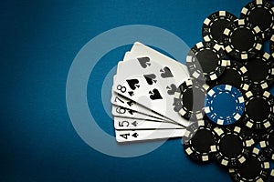 A gambling game of poker with a winning combination of straight flush. Cards with chips on a blue table in a poker club.