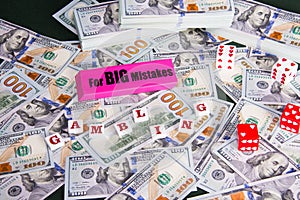 Gambling: Pink eraser with really big mistakes message, dice and scattered and stacked US dollars