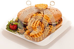 Gamburger with frenchfries on a plate isolated over white background