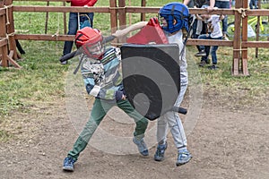 Game for boys. Children fight with swords and shields in defense and helmets.