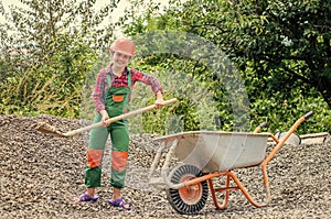 Game of builder and construction. Outdoor activity concept. girl who is transporting rubble in a wheelbarrow