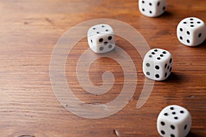 Game of chance concept. White dice on rustic wooden board.