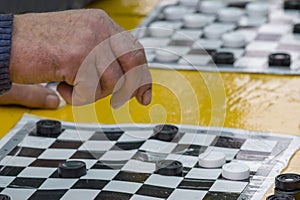 A game of checkers and a hand.