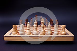 A game of chess, the beginning of a chess game two sides opposite each other.