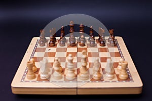 A game of chess, the beginning of a chess game two sides opposite each other.