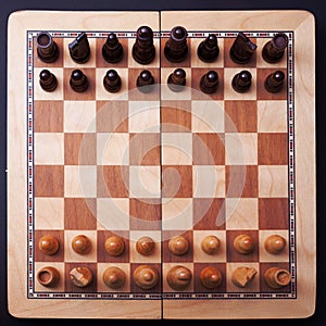 A game of chess, the beginning of a chess game two sides opposite each other.