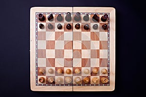 A game of chess, the beginning of a chess game two sides opposite each other.