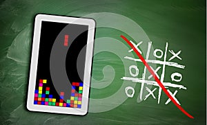 Game controller on tablet and ticktacktoe on chalkboard, concept