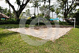Game court made on sand situated under a shady tree.