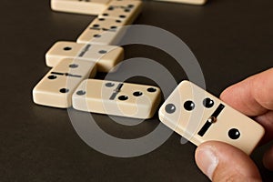 A game of dominoes on a dark table . The concept of the game of