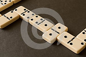A game of dominoes on a dark table . The concept of the game of