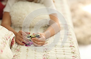 The game with the fidget spinner. Girl plays with Fidget Spinners at home on bed, the concept of relieving stress, develop a small