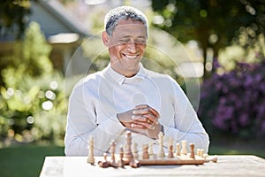 A game for the gifted. Shot of a senior man playing a game of chess outside.