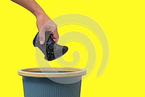 Game joystick is thrown into trash on yellow background.Concept of abandoning computer games