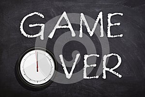 Game over text written with white chalk on chalkboard or blackboard.Time is over concept