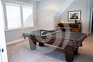 A game room or bonus upstairs room with a pool table converted to a table tennis game