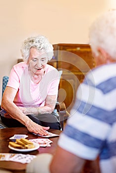 Game. Set. Match. Cropped shot of seniors playing cards in their retirement home.