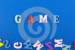 GAME word on blue background composed from colorful abc alphabet block wooden letters, copy space for ad text. Learning english