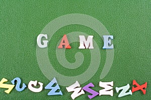 GAME word on green background composed from colorful abc alphabet block wooden letters, copy space for ad text. Learning english