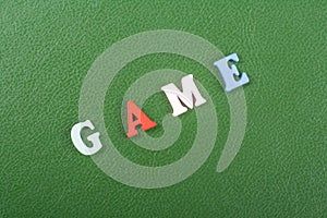 GAME word on green background composed from colorful abc alphabet block wooden letters, copy space for ad text. Learning english