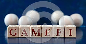 GAMEFI - word on wooden cubes on a blue background with wooden balls