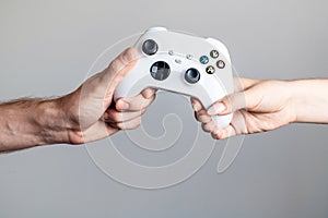The gamepad is in the hands of a man and a woman