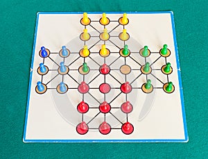 Gameplay of solitaire board game on green table