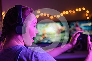 Gamer girl with a joystick plays on a console or computer using a gamepad, controller, joystick. Against the background of three